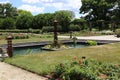 A man made pond with water plants and a sculpture surrounded by pathways and a rose garden in Hales Corners, Wisconsin Royalty Free Stock Photo