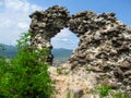 Man-made rock made from stones with a round hole, through which you can see the landscape of Khust. Amazing view of the ruins of Royalty Free Stock Photo