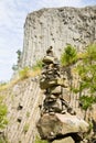 Man made stone tower outdoor, with unique basalt rock formation wall background.