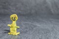 Man made of yellow play dough in front of grey background