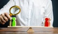 A man with a magnifying glass is looking at the rival red and green figures groups on scales. conflict resolution Royalty Free Stock Photo