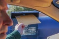 Man mailing tax return - large envelope at drive by mailbox with face blurred - selective focus