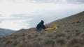 A man makes adjustments to his yellow plane