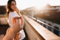 Man makes offer of marriage to girl standing on the roof on a sunny day. Outdoor portrait of young woman spending time