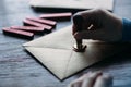 Man makes the stamp using sealing wax on the envelope