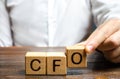 A man makes the word acronym abbreviation CFO. Chief Financial Officer. Financial management in business and company