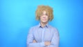 Man with makeup and a wig on a blue background . copy space Royalty Free Stock Photo