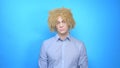 Man with makeup and a wig on a blue background . copy space Royalty Free Stock Photo