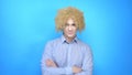 Man with makeup and a wig on a blue background . copy space Royalty Free Stock Photo