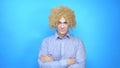 Man with makeup and a wig on a blue background . copy space Royalty Free Stock Photo