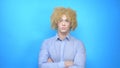 Man with makeup and a wig on a blue background . copy space Royalty Free Stock Photo