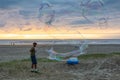 Man making big Soap Bubbles on the sandy beach Royalty Free Stock Photo