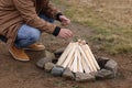 Man making bonfire outdoors, closeup. Camping season