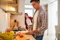 Man making breakfast for his smiling pleased spouse