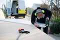 Man making a camper van outdoors. Cutting board with jigsaw. PPE equipment. eyewear, headphones and protective mask