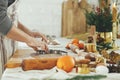 Man making christmas gingerbread cookies close up in modern white kitchen. Hands cutting gingerbread dough with festive golden Royalty Free Stock Photo