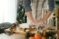 Man making christmas gingerbread cookies. Hands kneading gingerbread dough with rolling pin, golden cutters, cooking spices, Royalty Free Stock Photo