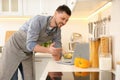 Man making dinner while watching online cooking course via laptop in kitchen Royalty Free Stock Photo