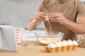 Man making dough while watching online cooking course via tablet in kitchen, closeup Royalty Free Stock Photo