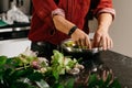 Man making flowers arrangment with green and white orhids