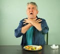 Man making the international sign for `I`m choking` as he chokes on food