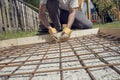 Man making a net of steel bars by clipping them together with a Royalty Free Stock Photo