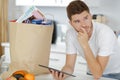 man making online purchase with tablet next to paper bag Royalty Free Stock Photo