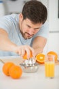 man making orange juice in kitchen Royalty Free Stock Photo