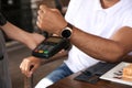 Man making payment with smart watch in cafe, closeup Royalty Free Stock Photo