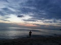 Waves, sunset, sea. Man making photo of sunset. Phuket, Thailand