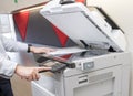 Man making photocopy of document on a copy machine with access control for key card.