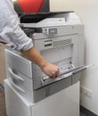 Man making photocopy of document on a photocopier machine with access control for key card.