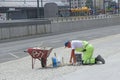 Man making repairing of sidewalk. Worker laying stone paving slab