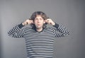 Man making silly monkey face isolated on grey background. Guy grimaces monkey. Funny male holding his ears and shows
