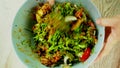 Man is making young tamarind leaves salad in blow