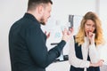 Man manager got mad at his colleague woman for mistakes in documents preparation before important deal standing in modern bright
