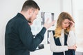 Man manager shouts at his colleague woman for mistakes in documents preparation before important deal standing in modern bright Royalty Free Stock Photo