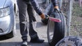 A man manually cleans the wheel surface of a car before replacing