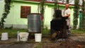 Man is manually mixing fruit marc in distillation apparatus for making domestic alcohol liquor