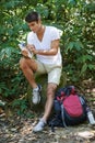 Man, map and reading for hiking in forest with search for thinking, holiday or ideas on path. Man, woman and bag for Royalty Free Stock Photo