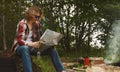 Man with map sits in front of bonfire Royalty Free Stock Photo