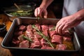 man marinating meat with thyme and rosemary Royalty Free Stock Photo