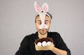 Man in the mask Easter rabbit looking at the eggs in hat Royalty Free Stock Photo