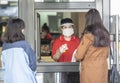A man in mask and face shield giving the change in a kiosk