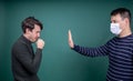 Man in mask fencing off coughing guy