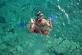 Man with mask snorkeling and doing ok sign