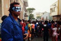 man with a mask watching the carnival event on the streets of the city