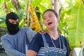 Man with masked robber and threatening with gun to scared woman in car parking. The victim of the crime was terrified and have anx Royalty Free Stock Photo