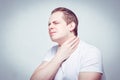 A man massages his neck in pain. The concept of chronic illness and the common cold