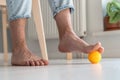 Man massaging arthritic feet with ball at home